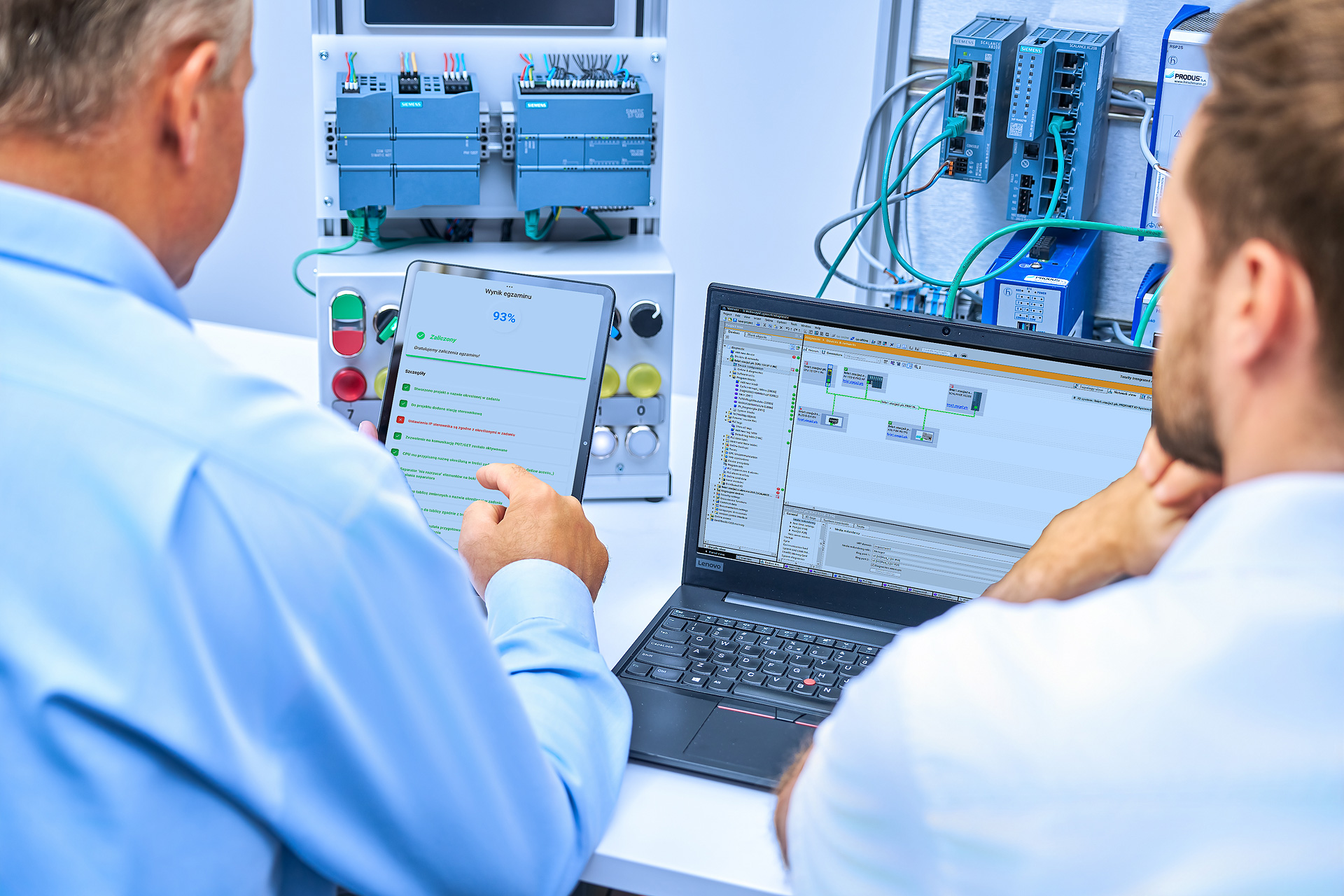 Egzaminator omawia z uczestnikiem wynik egzaminu praktycznego wyświetlony na tablecie
